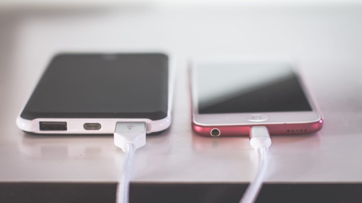 Picture of two phones on a table being charged.